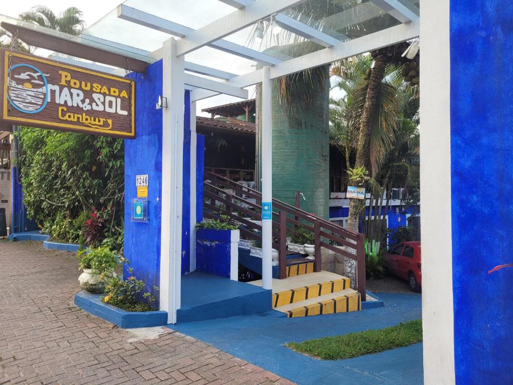 a blue building with a sign for a restaurant at Pousada Mar & Sol de Camburi in Camburi