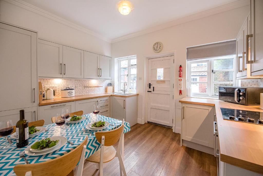 a kitchen with a table with a blue and white table cloth at Pelican Cottage, Aldeburgh in Aldeburgh