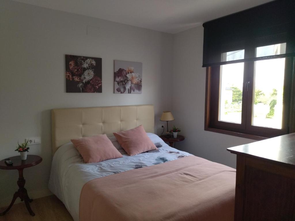 ein Schlafzimmer mit einem Bett mit zwei rosa Kissen in der Unterkunft Casanova in Fene