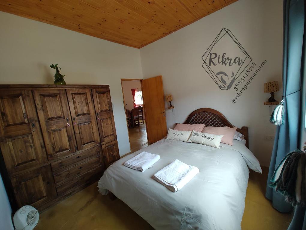 1 dormitorio con 1 cama con 2 toallas en Rikra Purmamarca en Purmamarca