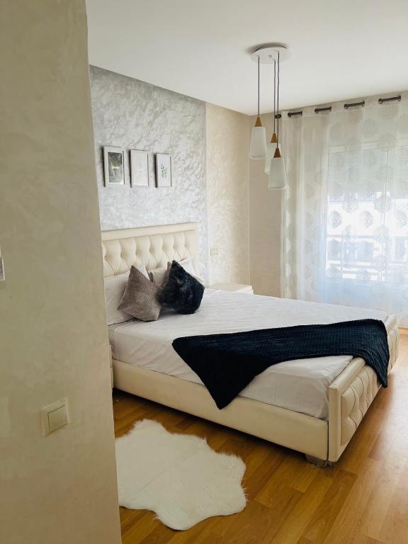 Superbe Appartement au coeur de Casablanca في الدار البيضاء: غرفة نوم مع سرير أبيض كبير في غرفة
