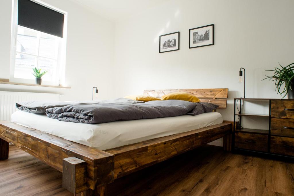 1 dormitorio con cama de madera en una habitación en Designapartment im Herzen der Altstadt - 3BR - 7 Guests - fully equipped kitchen, en Limburg an der Lahn