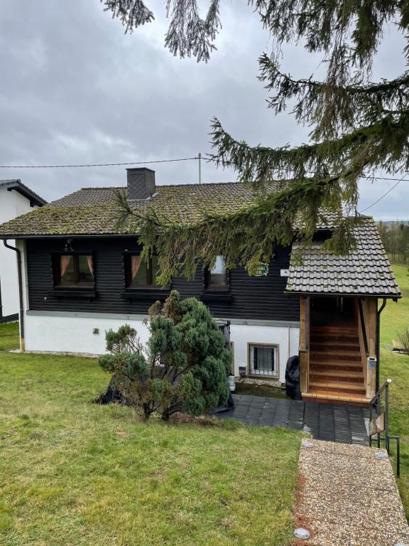 una casa en blanco y negro con un patio en Ferienhaus Buchali, en Harscheid