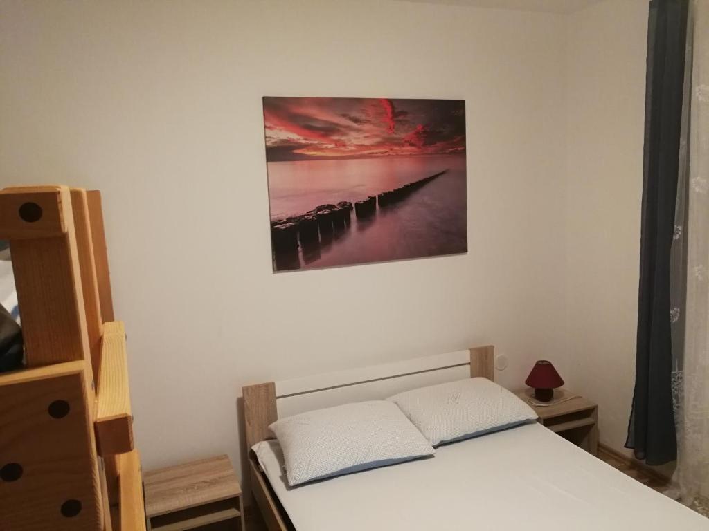 a bedroom with a bed and a picture on the wall at VILA RENATA in Grižane