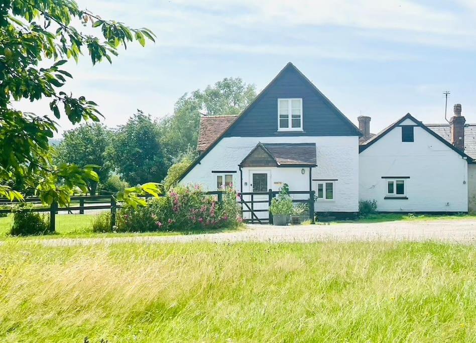a white house with a black roof at Barn Cottage -Westerlands in Graffham