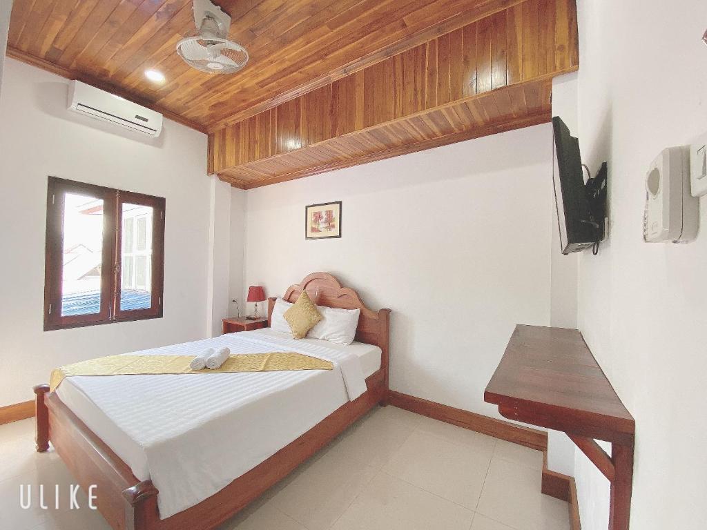 a bedroom with a bed and a wooden ceiling at Elephant Boutique Hotel in Luang Prabang