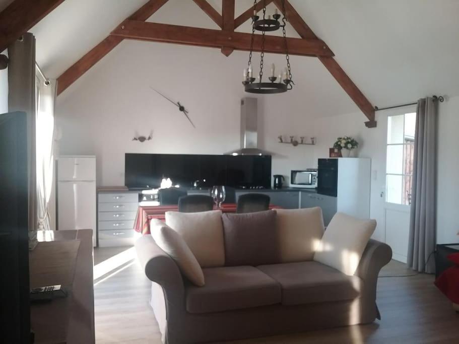 a living room with a couch and a kitchen at Maison indépendante et privative 52m2 au calme in Cléré-les-Pins