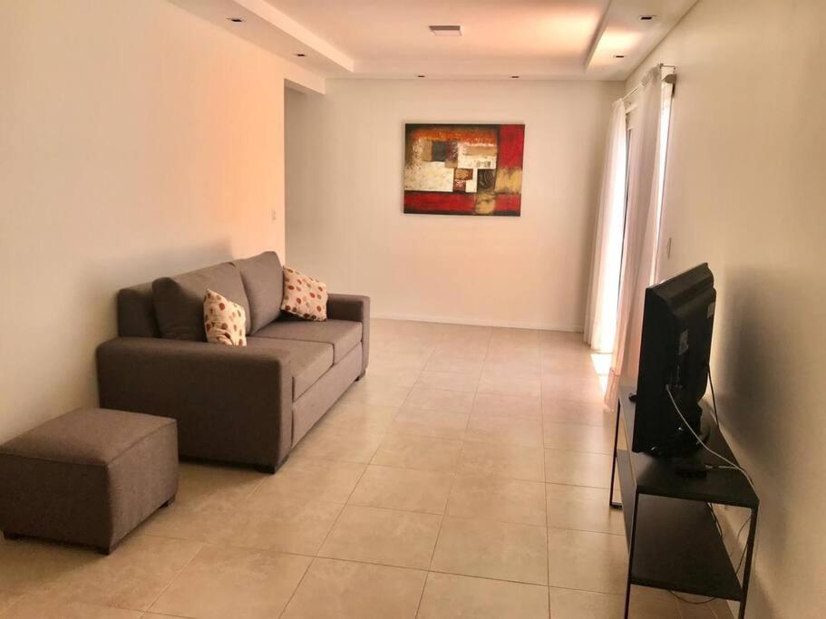 sala de estar con sofá y TV en Departamentos Dorrego en Mendoza