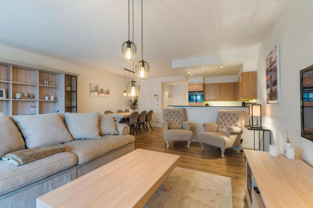 ein Wohnzimmer mit einem Sofa und einem Tisch in der Unterkunft Lichtrijk appartement in hartje Knokke vlak bij shoppingstraat & strand in Knokke-Heist