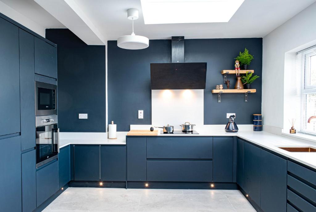 een keuken met marineblauwe kasten en witte aanrechtbladen bij Liberty Redcar in Redcar