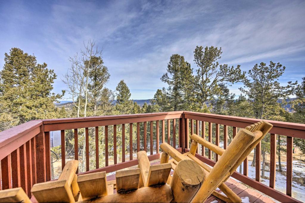 a wooden deck with two chairs and a table at Woodland Park Home with Stunning Mountain Views in Woodland Park