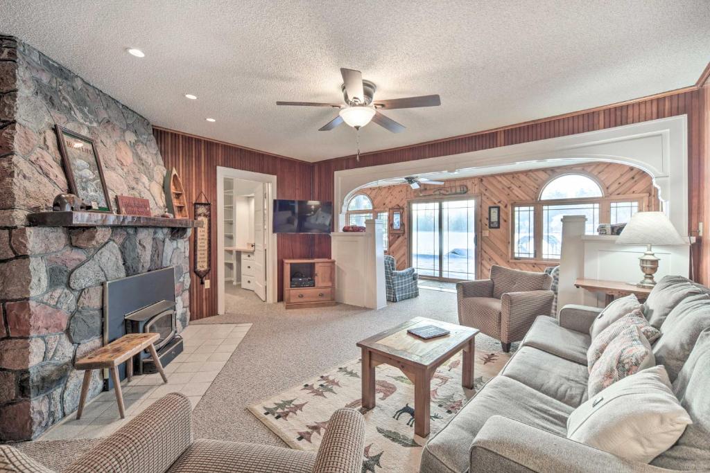 a living room with a couch and a fireplace at Spacious Home with Deck on Lake Chetek! in Chetek