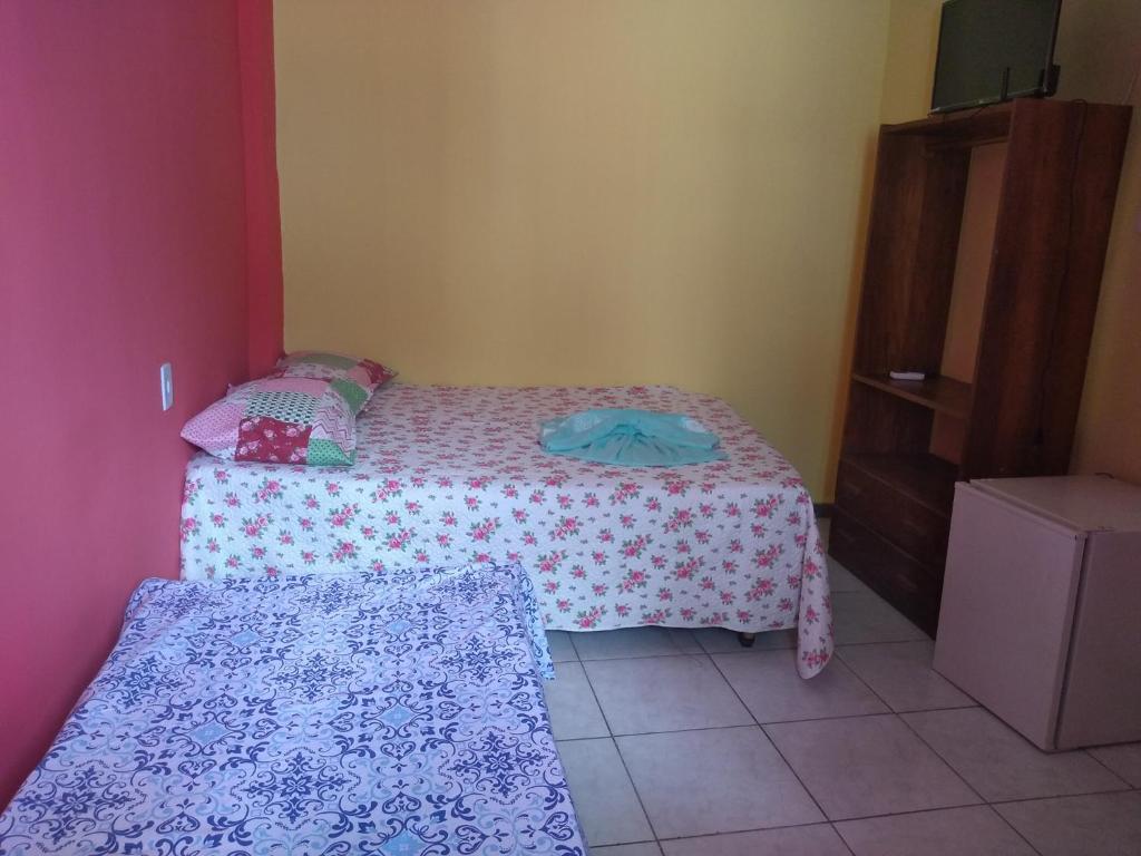 niewielka sypialnia z 2 łóżkami i komodą w obiekcie Pousada Residencial Benfica w mieście Porto Seguro