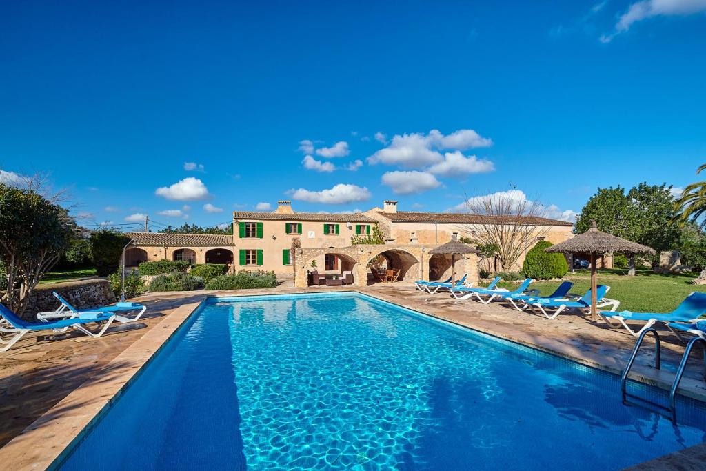 a pool with chairs and a house in the background at Finca Son Oliver by Mallorca House Rent in Felanitx