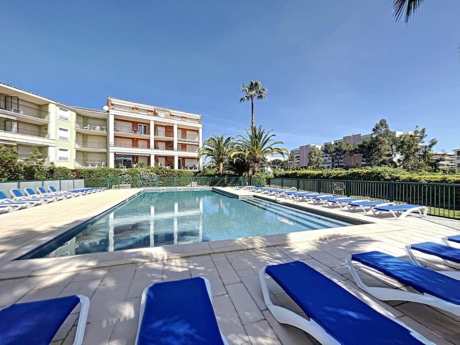 a swimming pool with lounge chairs and a building at Port Marine - T3 calme, avec terrasse, piscine, près de la plage in Sainte-Maxime