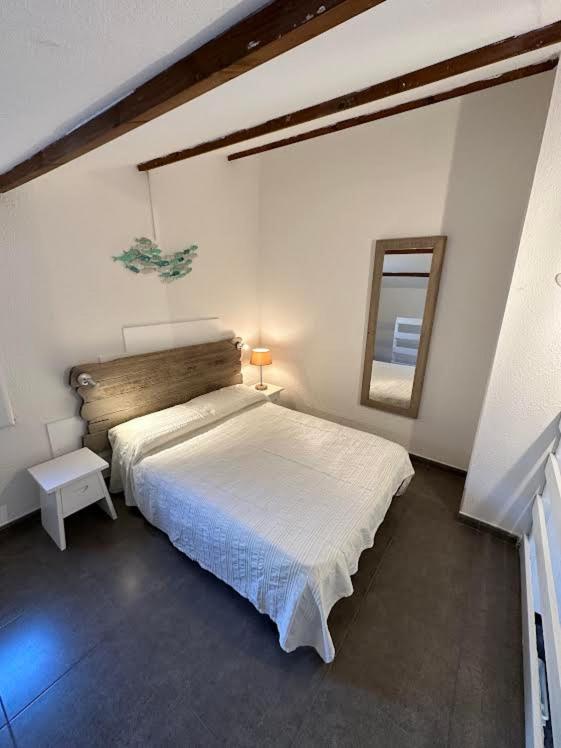 a bedroom with a large bed and a mirror at Maison D Santa Giulia in Porto-Vecchio