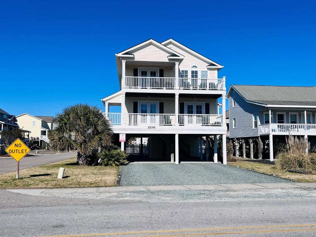 a house on the side of a street with a sign at 2 the C in Holden Beach