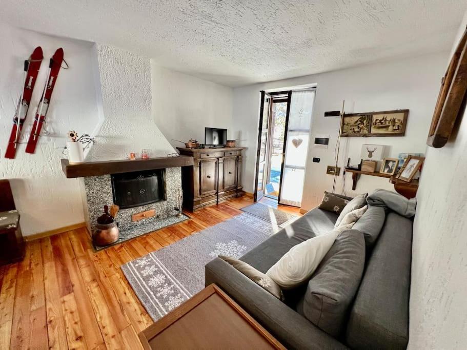 a living room with a couch and a fireplace at Chalet le Pigne Gressoney Saint Jean in Gressoney-Saint-Jean