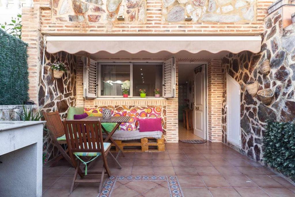 a patio with a table and chairs and a window at Villa del Mar in Puebla de Farnals