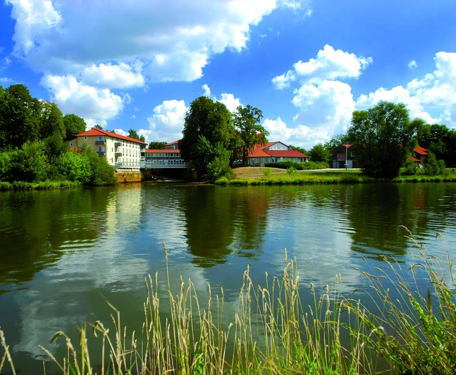 a view of a river with buildings in the background at Hotel Weserschlösschen in Nienburg