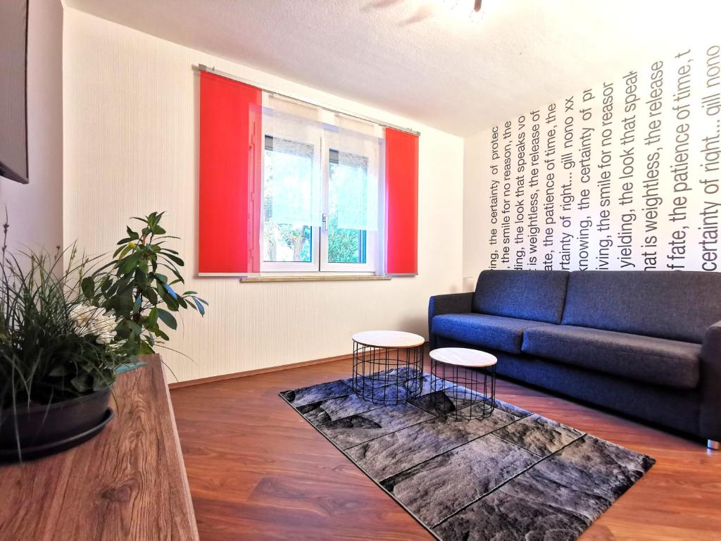 sala de estar con sofá azul y ventana en Ferienwohnung "Rosental" en Stützengrün