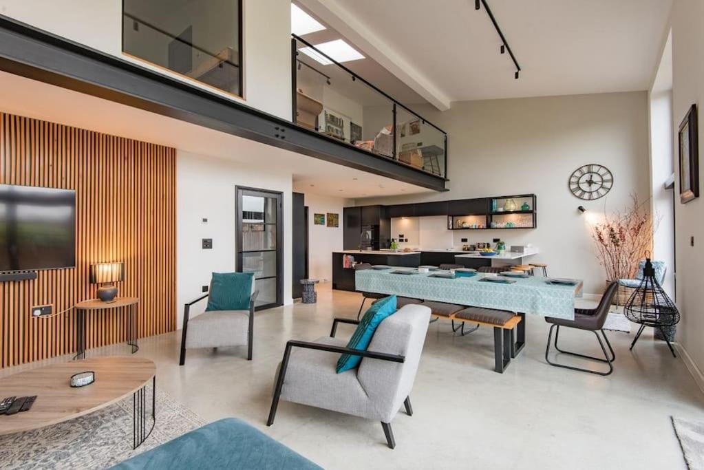 a living room with a large blue table and chairs at The Barn in Sandwich