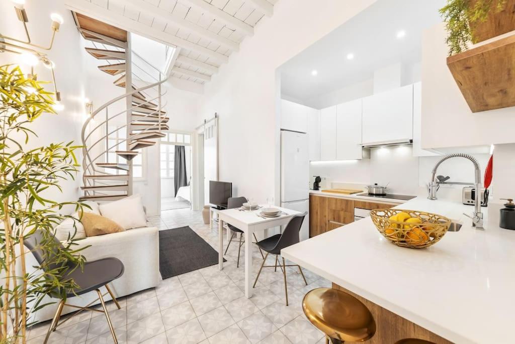 eine Küche und ein Wohnzimmer mit einer Wendeltreppe in der Unterkunft RG Casa do Carmo in Faro