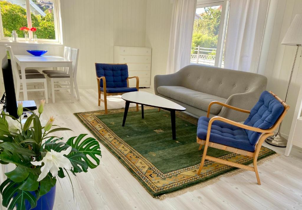 a living room with a couch and two chairs and a table at Helgas Hus tre rum o kök in Hunnebostrand