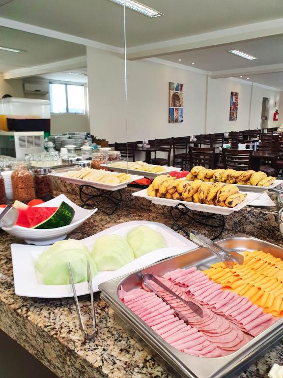 a buffet with many different types of food on a counter at Avenida Palace Hotel in Joinville