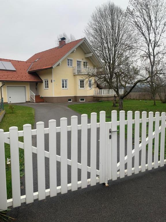 a white picket fence in front of a house at Ferienhaus Loretto in Wölzing