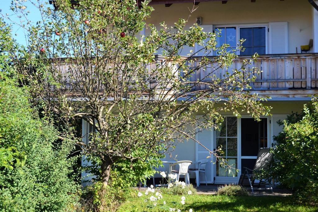 Casa con porche con mesa y silla en Ferienwohnung Am Anger, en Samerberg