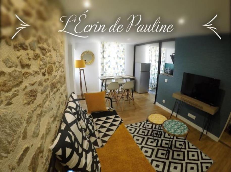 a living room with a couch and a television at L'Ecrin de Pauline in Dinan