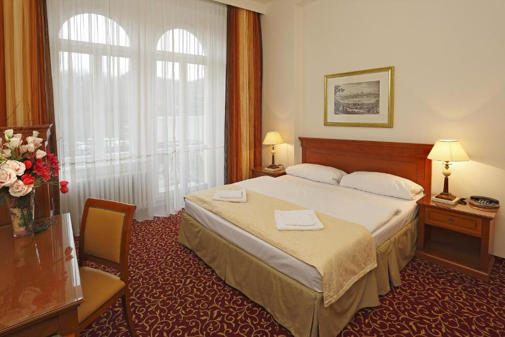 pokój hotelowy z łóżkiem i oknem w obiekcie Romania w Karlowych Warach