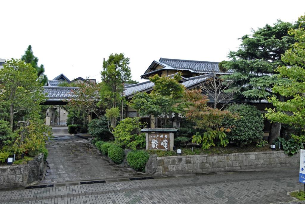 um edifício antigo com um jardim em frente em Ise Todaya Ryoan em Ise