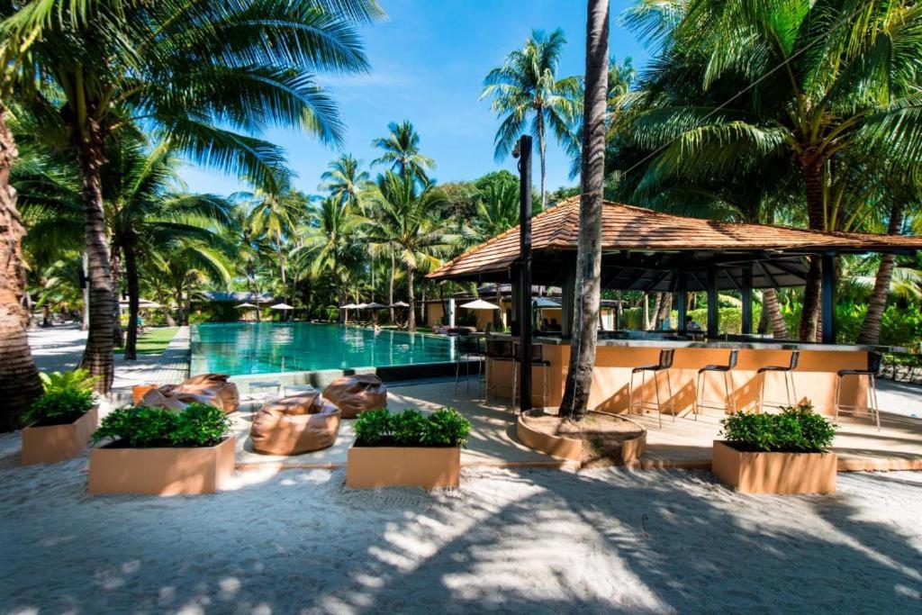 a resort with a swimming pool and palm trees at Siam Sunset Beach Villas in Ko Chang
