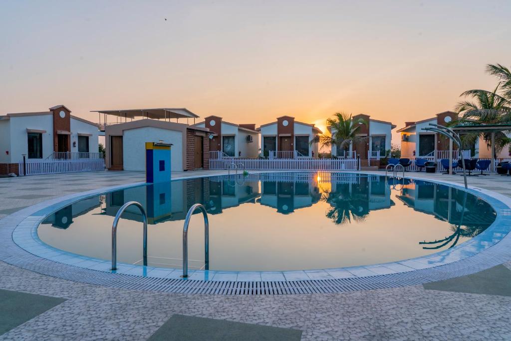 a swimming pool in front of some houses at Flamingo Club and Resort Una 3 Km Away from Diu Check Post in Diu