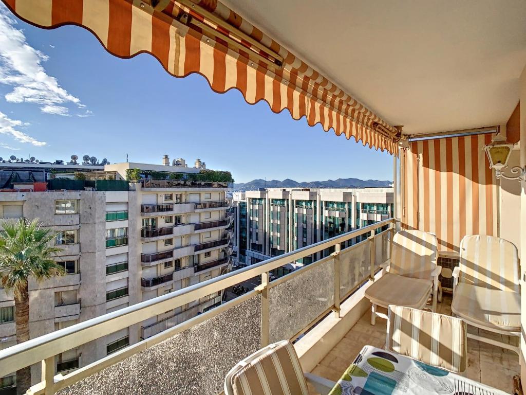 d'un balcon avec des chaises et une vue sur un bâtiment. dans l'établissement Studio luxueux et spacieux avec terrasse, à Cannes