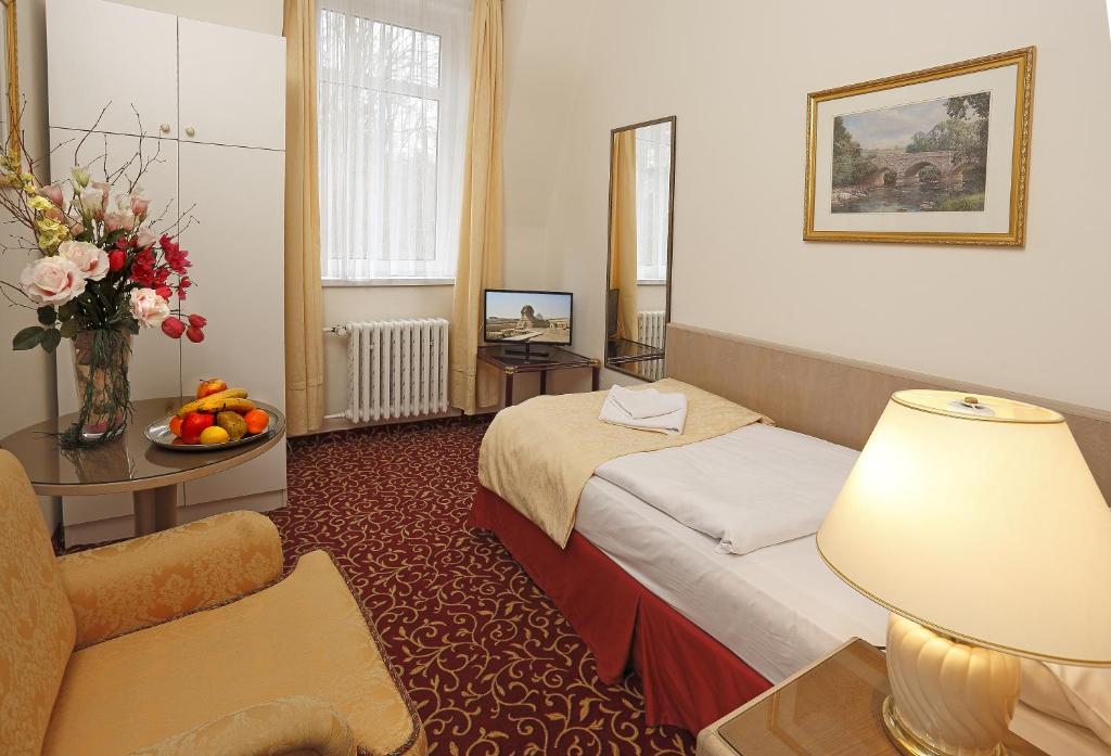 pokój hotelowy z łóżkiem i stołem w obiekcie Romania w Karlowych Warach
