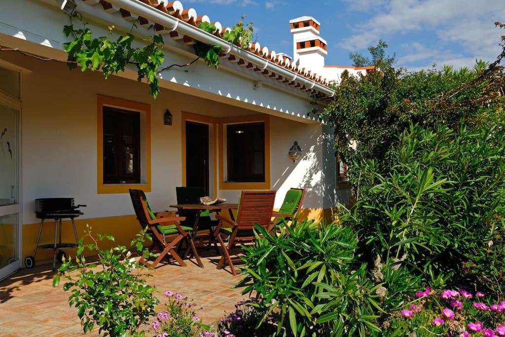 a patio of a house with chairs and a table at Vale do Guizo: Casa Poente on the contryside, close by the sea. in Aljezur