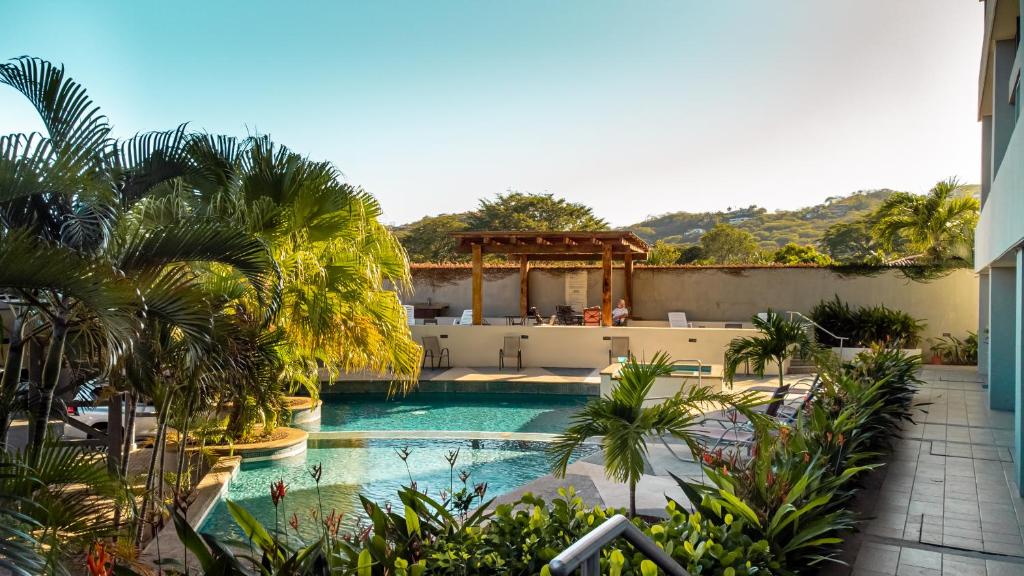 una piscina en un complejo con palmeras en CasaGuana en Playa Hermosa