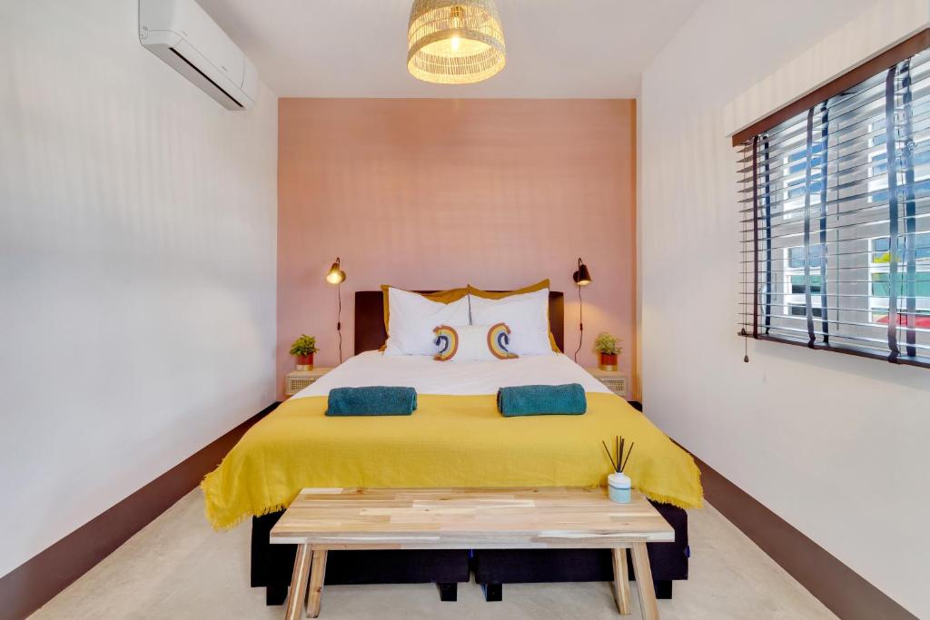 a bedroom with a bed with a yellow blanket at New & luxurious Two Bedroom Apartment at the Water in Kralendijk