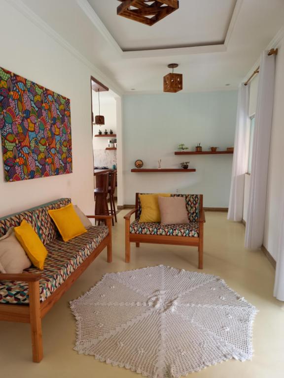 ein Wohnzimmer mit 2 Sofas und einem Teppich in der Unterkunft Casa Doce Lar Caraíva in Caraíva