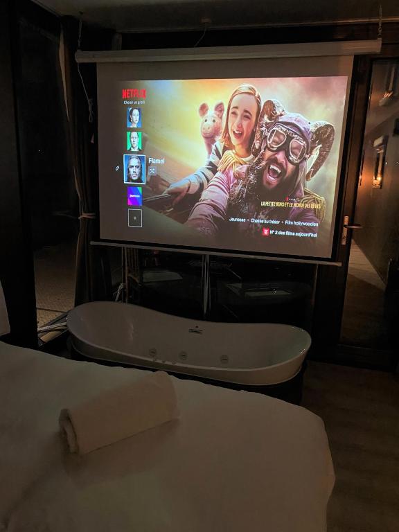 a flat screen tv with a movie projected on it at L&#39;Escale Royale L&#39;Isle Adam à 20 minutes de Paris CDG in LʼIsle-Adam