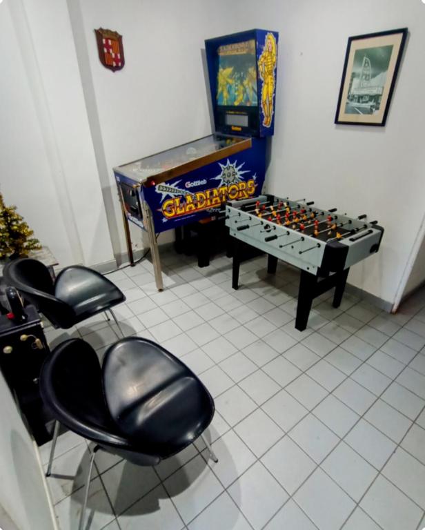 Habitación con mesa de ping pong y sillas. en Gladiadores en Salta