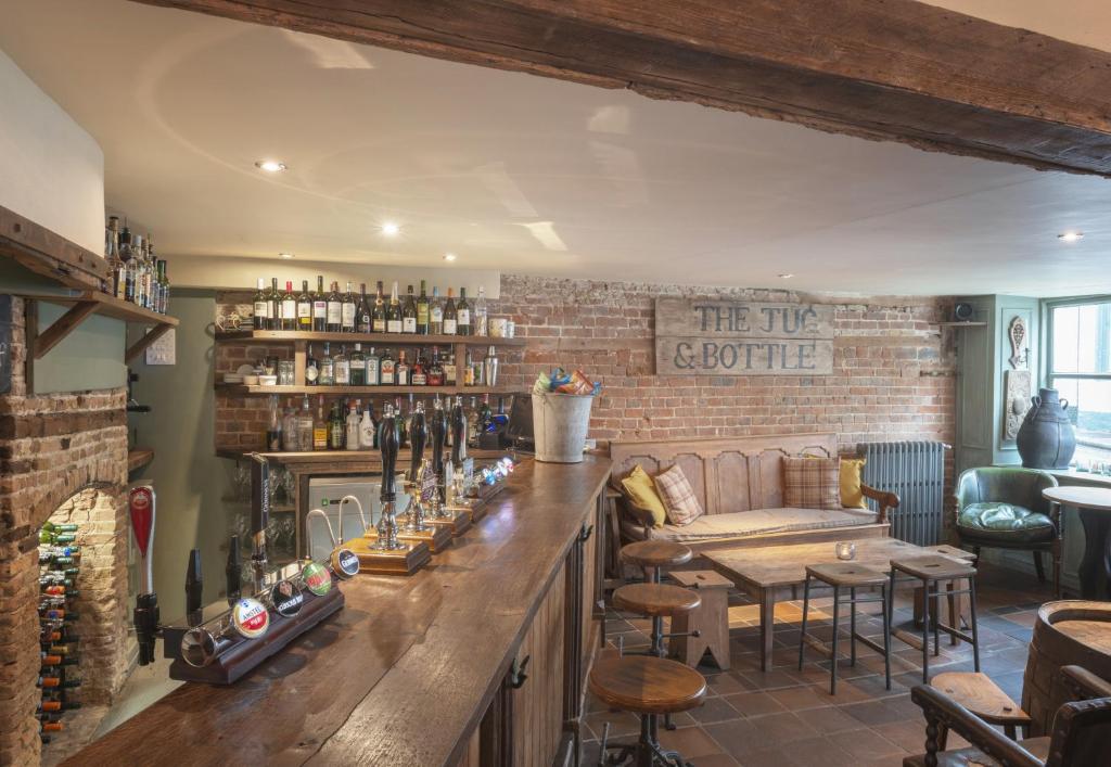 a bar in a restaurant with a brick wall at The Standard Inn in Rye