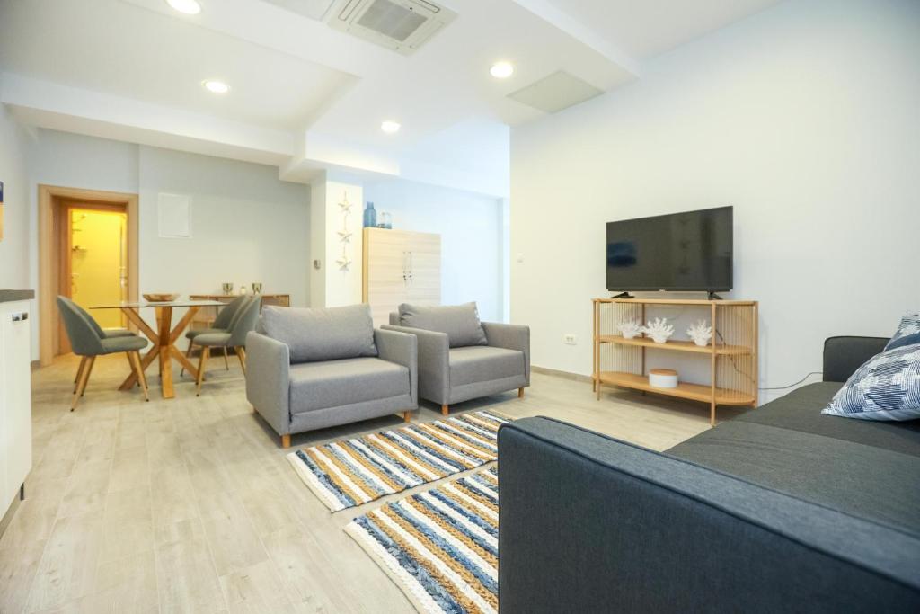 Televízia a/alebo spoločenská miestnosť v ubytovaní Apartmani Kolovare