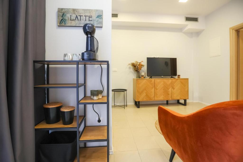 Televízia a/alebo spoločenská miestnosť v ubytovaní Apartmani Kolovare