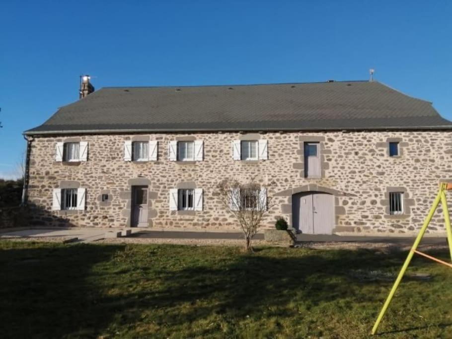 a large stone house with a large yard at LA MAISON DES HIRONDELLES in Cussac