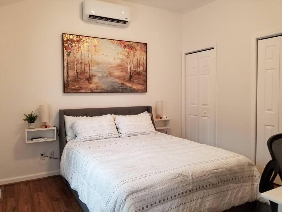een slaapkamer met een bed en een schilderij aan de muur bij Tiny home rentals near Ft Moore in Phenix City