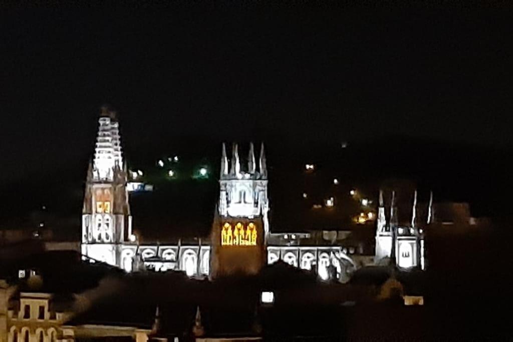 a lit up building with a clock tower at night at LUXEinBurgos Atico con Vistas Espectaculares in Burgos